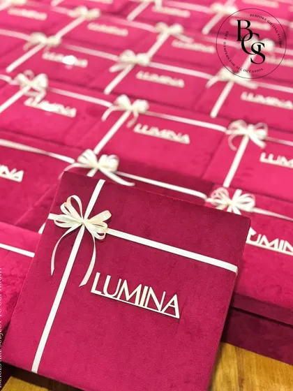 For corporate events that demand sophistication, I create custom-branded packaging that speaks your brand's language. These plush velvet boxes, personalized for the 'LUMINA' launch, show how I can translate a theme into a tangible, luxurious experience for your guests.