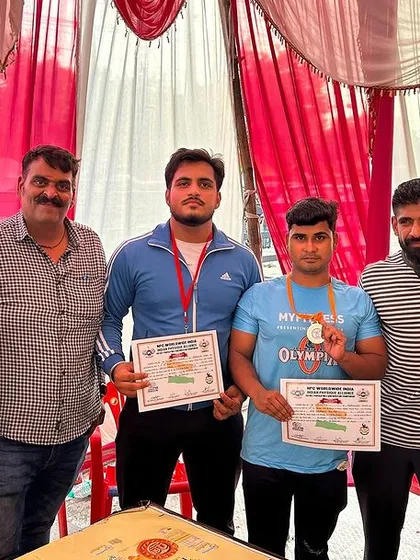 Standing with fellow medal winners at the NPC district powerlifting event. Hard work pays off.