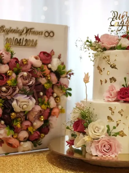 This engagement cake was designed to match the couple's beautiful floral invitation box. The two-tiered cake features a delicate buttercream finish, edible gold leaf, and carefully placed sugar flowers to create a cohesive and romantic theme.
