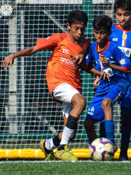 A player uses his body to shield the ball effectively. Game intelligence and physical play are key skills we teach.