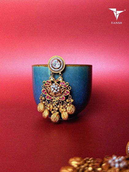 Lotus motifs, pearls, and meenakari craftsmanship come together in these earrings. The gold accents add just the right amount of drama for a festive or bridal look.