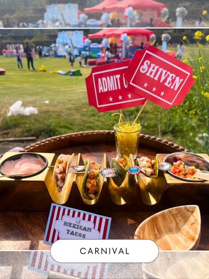 Delicious Mexican Tacos served with custom 'Admit One' ticket toppers for a carnival party. In the background, you can see the large, festive outdoor setup, showing how the food is part of a bigger experience.