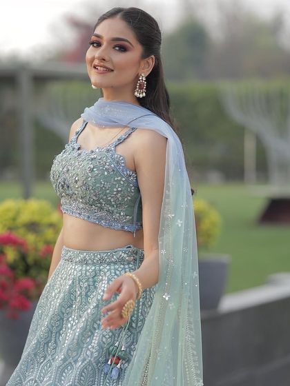 A close-up portrait in the ice blue lehenga, showing the intricate beadwork on the blouse and the model's fresh, summery look.