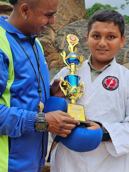 This young champion's face beams with pride as he holds his large trophy. These victories build confidence that lasts a lifetime.
