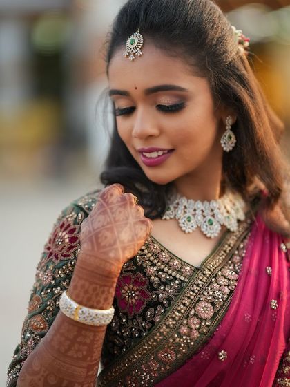 A close-up of Dr. Saruna, showing the details of her makeup and her intricate henna design. The look is both glamorous and traditional.