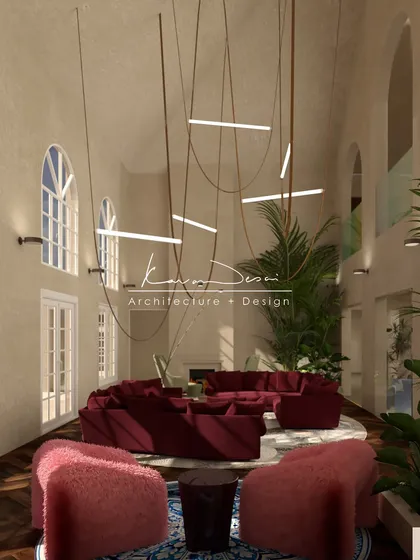 A wide shot of the luxurious living room, showcasing the combination of the deep red sofa, plush pink armchairs, and intricate blue rug. It’s a space that is layered with color, texture, and personality.