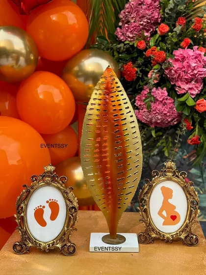 Close-up of the small, thoughtful details at the baby shower, including framed graphics of baby feet and a pregnant silhouette. These touches add a sweet and personal layer to the overall decor.
