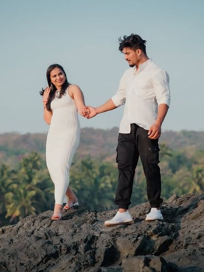 The groom-to-be leads his partner by the hand over the rocks. This shot tells a story of trust, guidance, and embarking on a new adventure together.