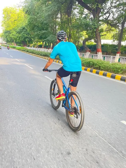 A shot from behind, showing a cyclist riding down a clean, tree-lined road. This captures the simple pleasure of a weekend ride.