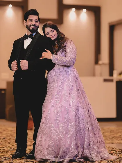 A stylish and classic portrait from a reception. The bride rests her head on the groom's shoulder as he stands confidently in his tuxedo. This pose is elegant and timeless, perfectly capturing the formal yet intimate feel of the celebration.