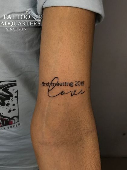 A script tattoo commemorating a "first meeting 2018" with the word "love."