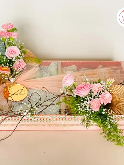 A full view of a personalized trousseau box, showcasing the elegant floral arrangements and a custom gold acrylic tag. This is how we make every gift feel truly special.