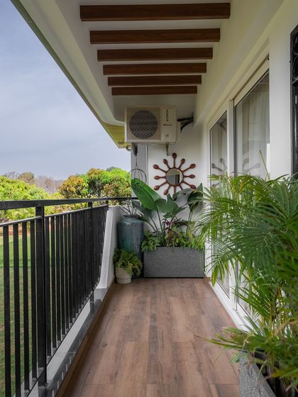 This balcony at Nambiar Bellezea is a light, fresh, and soulfully refined space. It features wooden flooring, simple black railings, and plenty of room for greenery, connecting the indoors with the lush view outside.