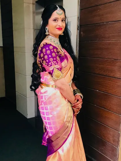 A side view of the Varapooje look, showing off the beautiful embroidered blouse and the long, flowing curls.