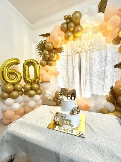 A beautiful shot of the 60th birthday celebration, with our cake perfectly matching the gold and white balloon decor.