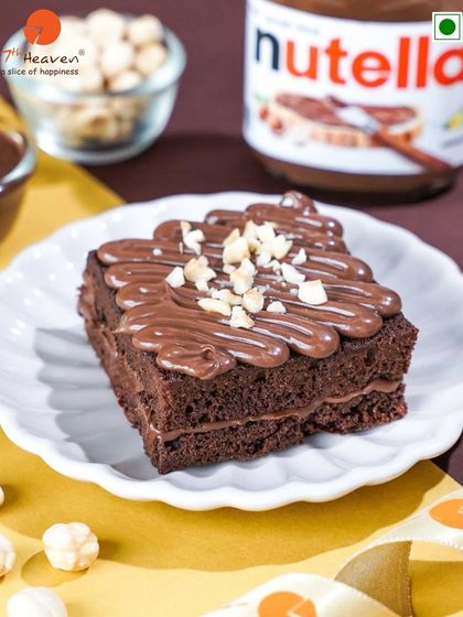 A delicious Nutella brownie, perfect for a midweek treat. This fudgy brownie is layered and topped with a generous amount of Nutella and chopped hazelnuts.