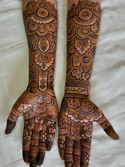 This intricate design was for an engagement bride. It features fine lines, detailed paisleys, and personalized elements written in beautiful calligraphy.