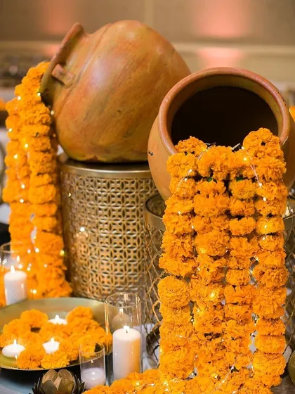 For festive occasions like Diwali, I create stunning decor arrangements. Here, I've used old terracotta pots to create a "waterfall" of marigold flowers and fairy lights, surrounded by the warm glow of candles.