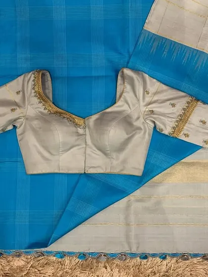 A cobalt blue and grey silk saree paired with a simple yet elegant grey hand-embroidered blouse.