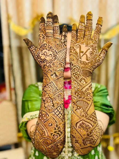 A full bridal design that features the groom's initial "K" prominently on the palm.