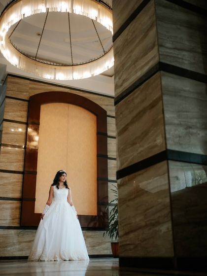 A grand setting for a beautiful bride. Her timeless makeup and hair look elegant and sophisticated, perfectly fitting the luxurious ambiance of her wedding venue.