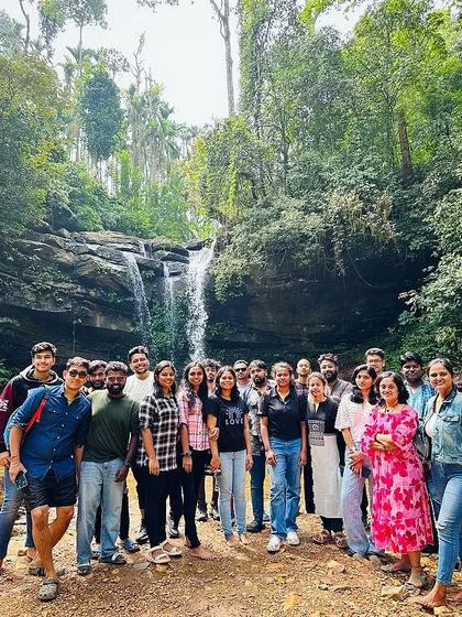 Another angle of the group at the waterfall, capturing the lush green surroundings of Chikmagalur.
