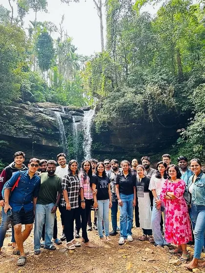 The New Year's batch posing for a group photo in front of a waterfall in Chikmagalur.