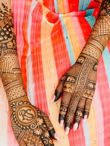 This stunning bridal design combines personalized initials with traditional elephant motifs and intricate jaal patterns, creating a balanced and beautiful look.