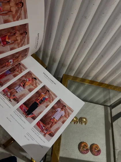 Looking through a designer's lookbook. This is a crucial part of my process as a personal shopper, finding the perfect pieces that align with my client's vision.