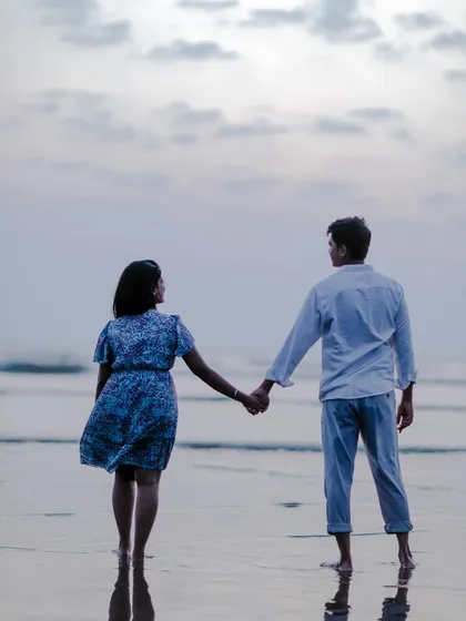 A quiet moment of a couple holding hands and looking out at the sea, capturing a sense of shared dreams and togetherness.