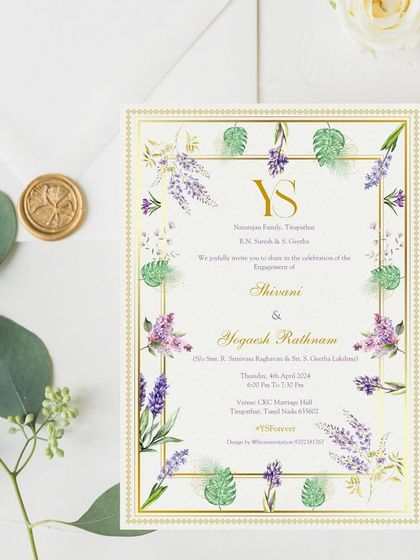 A closer look at the elegant printed engagement invitation for Yogaesh and Shivani. The design features a border of watercolor purple blooms and tropical leaves, with a classic gold frame and monogram for a touch of luxury.