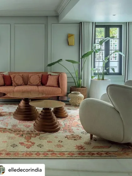 A detail from the 'Summer Haus' living room, where we layered textures and patterns to create a rich, eclectic mood. The combination of a patterned rug, sculptural wooden tables, and soft upholstery results in a space that is both visually dynamic and deeply comfortable.