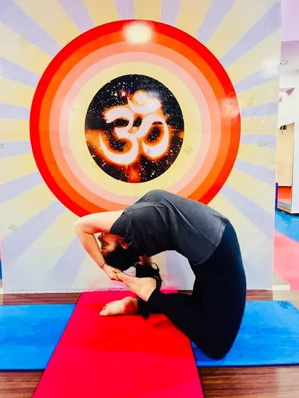 A student works on her Kapotasana, demonstrating the deep spinal flexibility that can be developed over time with consistent practice.