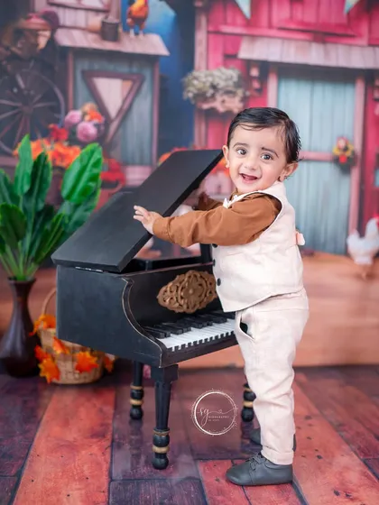 Ready to play a tune, this little one stands by the mini piano in a barnyard setting, creating a fun and interactive portrait.