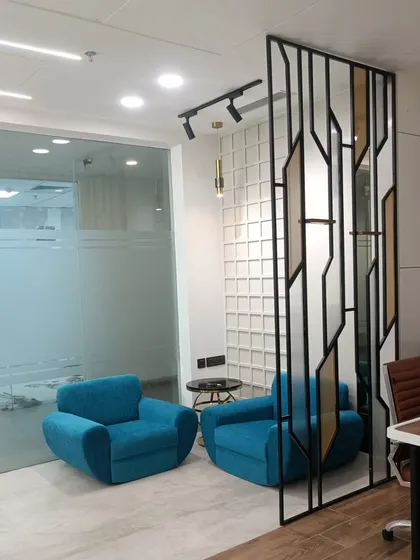 The waiting lounge in the CA office, featuring vibrant blue armchairs and a textured feature wall. This area provides a comfortable and professional first impression for visiting clients.