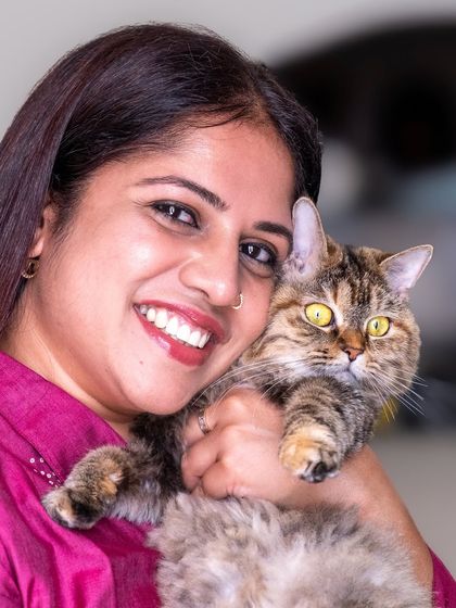 The pure joy on a pet parent's face while holding her cat says it all. This is a beautiful example of the love and happiness pets bring into our lives.