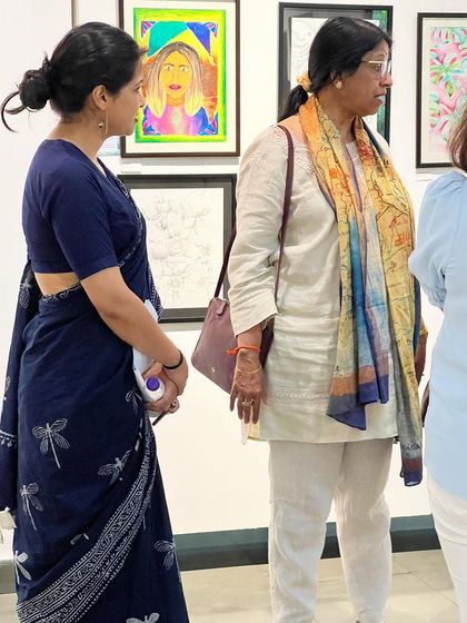 A candid moment from our student art exhibition, with guests and artists discussing the works on display.