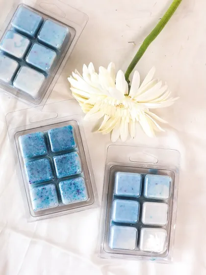 Our blue-toned wax melts, styled with a white gerbera daisy. These bring a fresh and clean scent to any room.