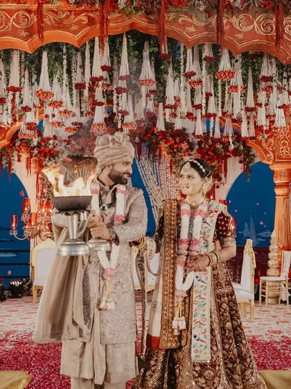 The couple participating in the Ganga Aarti, a divine and sacred part of their wedding ceremony. We ensure these significant traditions are photographed with reverence and beauty.