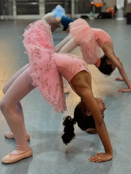 Building a strong and flexible body is a key part of our dance training. In our kids' ballet and jazz classes, we guide students through conditioning exercises like backbends, helping them develop core strength and agility in a fun, supportive group setting. Look at these young ballerinas in their pink tutus, getting stronger with every class.