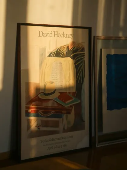 I find great inspiration in timeless art. This image showcases a piece from my collection of framed art, inspired by vintage exhibition posters like this one by David Hockney, designed to bring a touch of modern elegance to any wall.