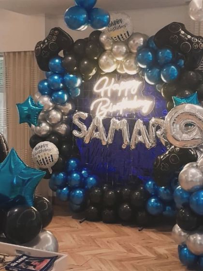 This gaming-themed decor is perfect for older kids, featuring a balloon wall in blue, black, and silver, with foil balloons shaped like game controllers.