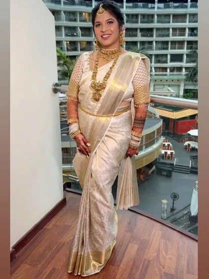 The timeless elegance of an Ivory and Gold Kanjeevaram saree, perfectly pre-pleated for this bride's Phera ceremony. My service ensures the drape is flawless, allowing her natural glow to be the focus.
