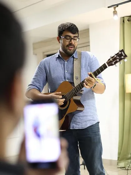 An audience member captures a musician's performance on their phone.