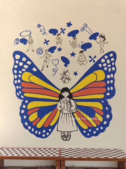 This butterfly mural features simple, cheerful wings and doodles above that depict children in various positive activities.