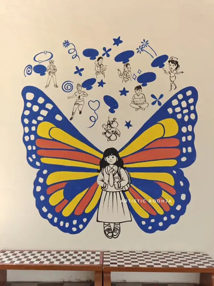 This butterfly mural features simple, cheerful wings and doodles above that depict children in various positive activities.