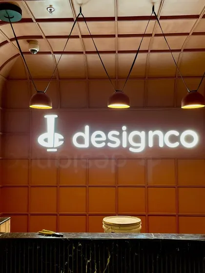 For the DesignCo office, we used lighting to reinforce their brand identity. The backlit signage creates a bold focal point at the reception, while suspended pendants provide functional, warm light over the desk, making the entrance both impressive and welcoming.