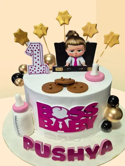 A "Boss Baby" themed cake for a first birthday. This fun design includes a baby bottle, cookies, and the iconic Boss Baby girl topper.
