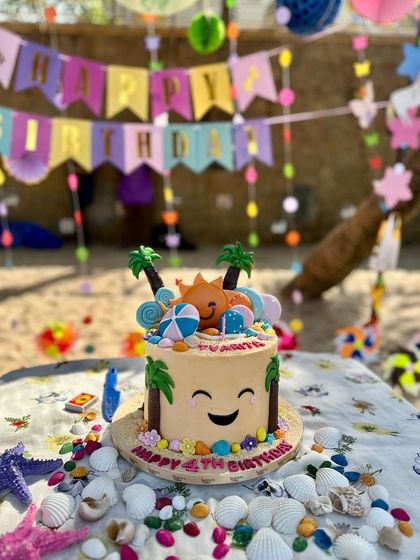 A cheerful beach-themed cake perfect for a sunny birthday party. This design features a smiling sun, palm trees, and other beachy details, bringing a splash of fun to the celebration.