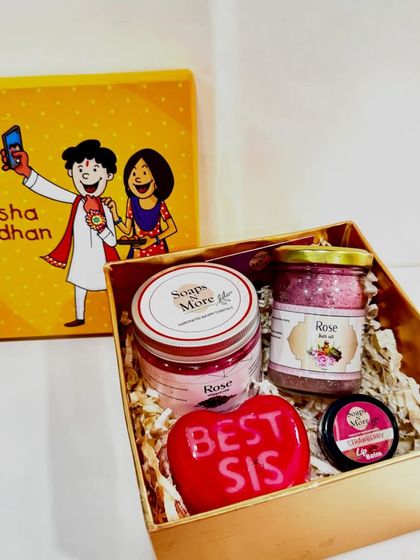 Pamper your sister this Raksha Bandhan with a skincare hamper. This set includes a 'Best Sis' soap, rose whipped soap, rose bath salts, and a tinted lip balm for a complete glow-up.